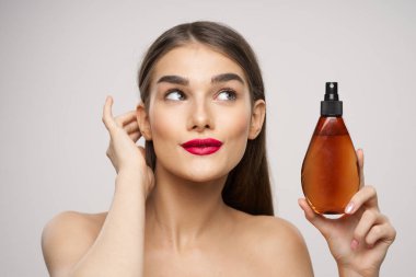 Stüdyoda güzellik ürünüyle güzel bir kadın var. 