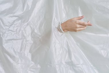 Kadın eli plastiği yırtıyor, polietilen.