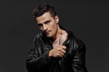 Karanlık arka planda genç ve seksi bir adam. Stüdyo çekimi  