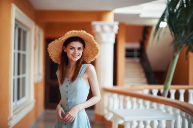   Tropik tatil köyünde hasır şapkalı genç bir kadın. 