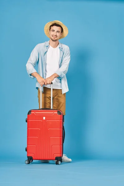 若いです男とともに赤いスーツケースでスタジオ — ストック写真