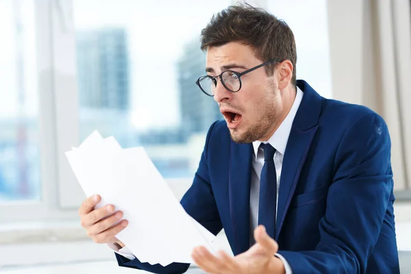 very angry businessman working  in the office  with documents