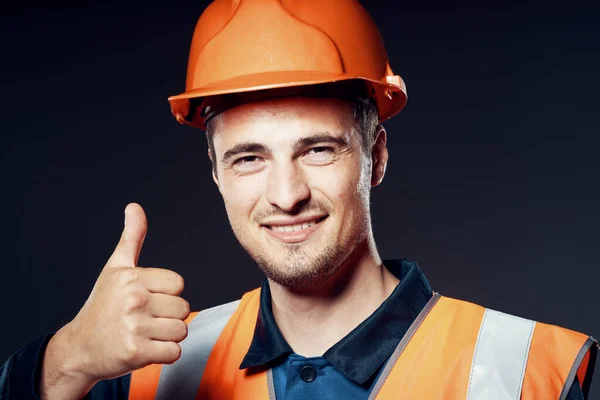 Studio shot. Industrial  worker in orange helmet with thumb up