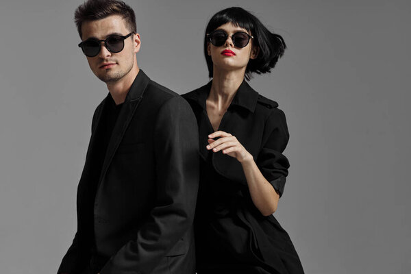 Young beautiful couple in black posing in studio