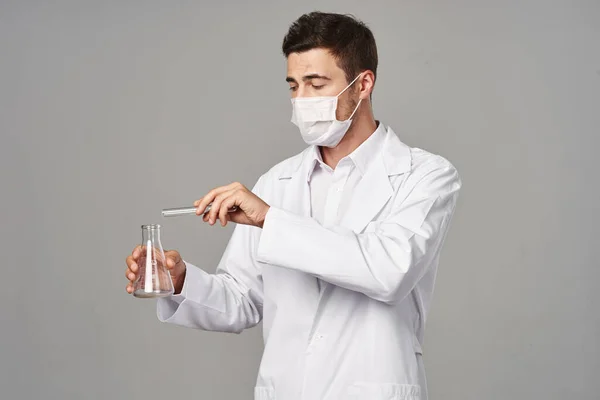 灰色の背景に試験管付きマスクの医師 スタジオショット — ストック写真