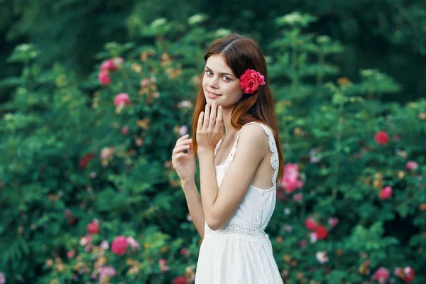 庭にバラの花を持つ若い女性 — ストック写真