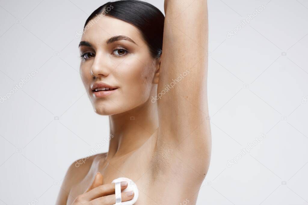 young beautiful woman cleaning face skin in studio 