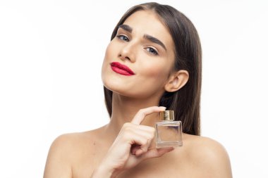 Beyaz arka planda parfüm şişesi olan güzel bir kadının portresi.