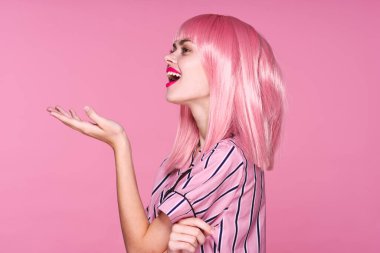 Stüdyoda poz veren pembe peruklu güzel bir kadın. 