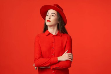 Stüdyo çekimi. Kırmızı şapkalı güzel kadın, kırmızı arka planda izole edilmiş.