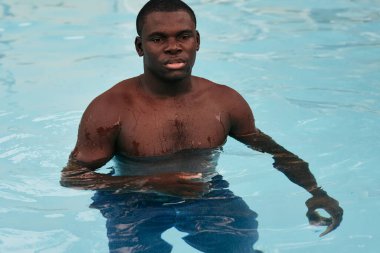 Havuzda poz veren genç yakışıklı adam.