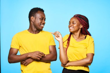 Genç ve güzel bir çift stüdyoda mavi arka planda konuşuyor.