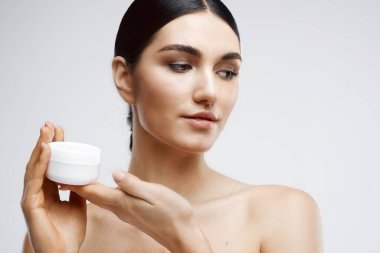 Güzel bir kadın çıplak omuzlarıyla cilt bakımına gider.