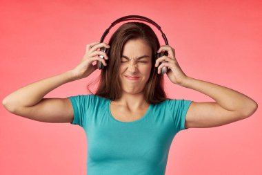 Kulaklıklı genç bir kadın müzik dinliyor.