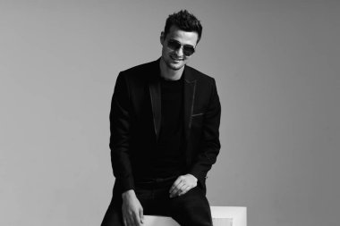 Stüdyo çekimi. Güneş gözlüğü takan genç yakışıklı adamın portresi.