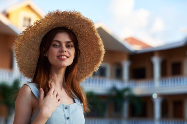   Tropik tatil köyünde hasır şapkalı genç bir kadın. 