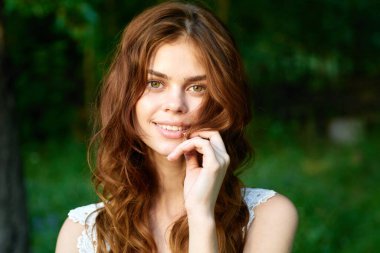 Yaz bahçesinde poz veren güzel bir kadın. 