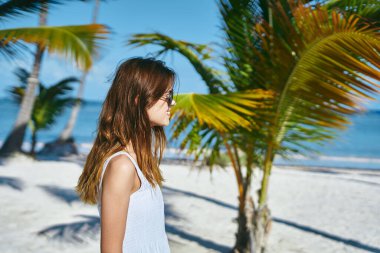 Genç ve güzel bir kadın sahilde dinleniyor.