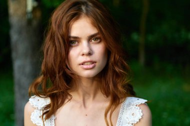 Yaz bahçesinde poz veren güzel bir kadın. 