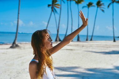 Genç ve güzel bir kadın sahilde dinleniyor.