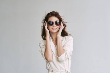 Stüdyoda poz veren güneş gözlüklü güzel bir kadın.  