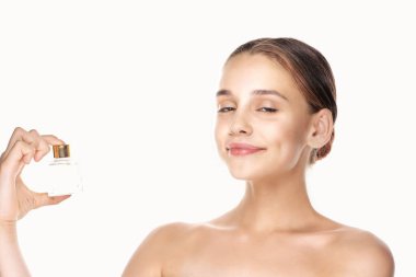 Beyaz arka planda parfüm şişesi olan güzel bir kadının portresi.