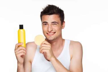 Stüdyo çekimi. Genç yakışıklı adam yüzünü yıkıyor. 