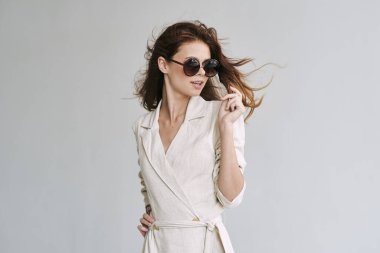 Stüdyoda poz veren güneş gözlüklü güzel bir kadın.  