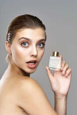 Parfüm şişeli güzel bir kadının portresi. Stüdyo çekimi.  