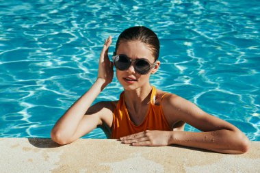 Genç ve güzel bir kadın havuzda dinleniyor.  