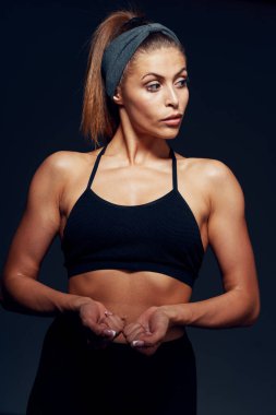 Stüdyo çekimi. Tecrit edilmiş, kaslı, genç bir kadın.   