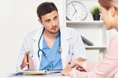 Kadın hasta hastanede bir doktoru ziyaret ediyor. 