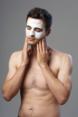 Genç adam yüz maskesi takıyor. 