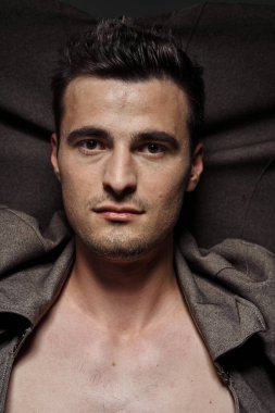 Stüdyoda poz veren genç yakışıklı adam.