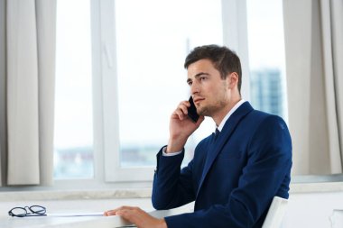 İş konsepti. Yong işadamı akıllı telefondan konuşuyor. 