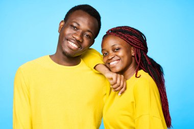 Stüdyoda mavi arka planda poz veren genç ve güzel bir çift