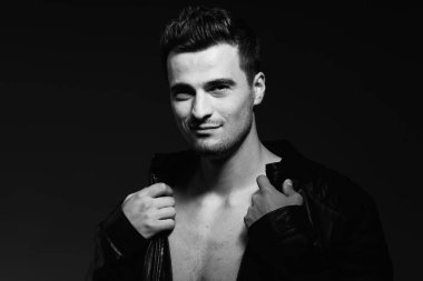 Stüdyoda poz veren yakışıklı bir genç. Siyah ve beyaz  