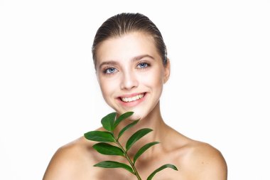 Stüdyoda yaprak ile poz veren genç güzel model.