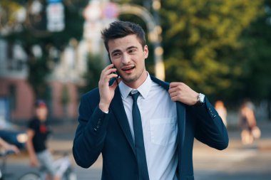 Genç ve yakışıklı iş adamı akıllı telefonları alıyor.