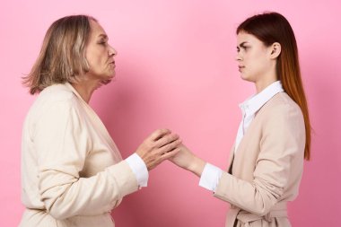 Stüdyoda annesiyle el ele tutuşan genç bir kadın. 