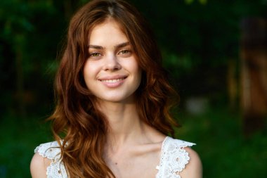 Yaz bahçesinde poz veren güzel bir kadın. 