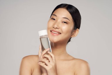 Stüdyo çekimi. Genç Asyalı kadın portresi ve güzellik ürünü.