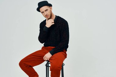 Stüdyoda poz veren şapkalı genç, yakışıklı bir adam.