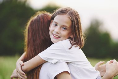 Genç anne ve kızı papatya tarlasında eğleniyorlar.