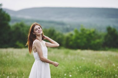 Kırsalda poz veren genç bir kadın. 