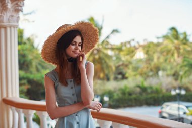   Tropik tatil köyünde hasır şapkalı genç bir kadın. 