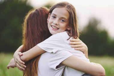 Genç anne ve kızı papatya tarlasında eğleniyorlar.