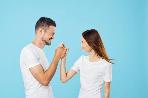 Young  couple armwrestling  in studio on isolated background