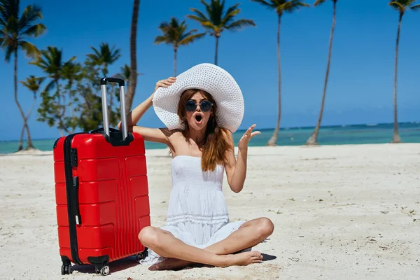 南国のビーチでスーツケースを着た若い美少女が — ストック写真