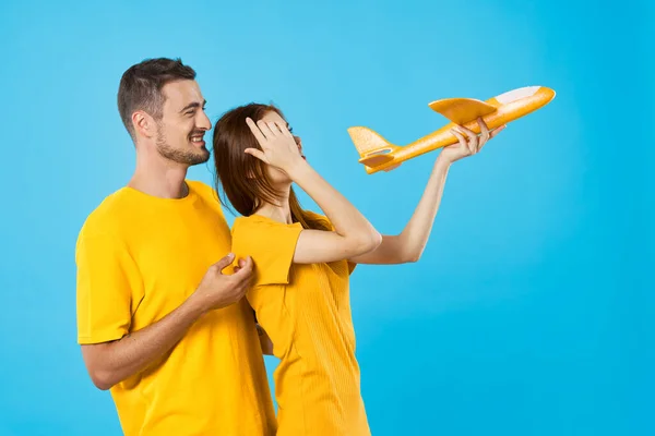 Genç Güzel Bir Çift Mavi Arka Planda Sarı Oyuncak Uçakla — Stok fotoğraf